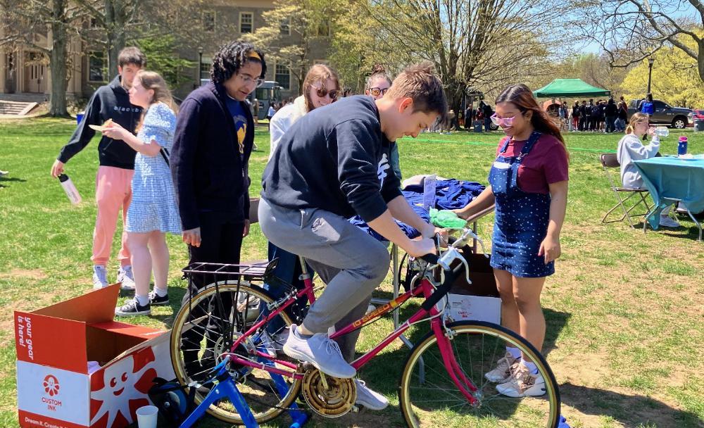 Students charging a phone with a stationary bike