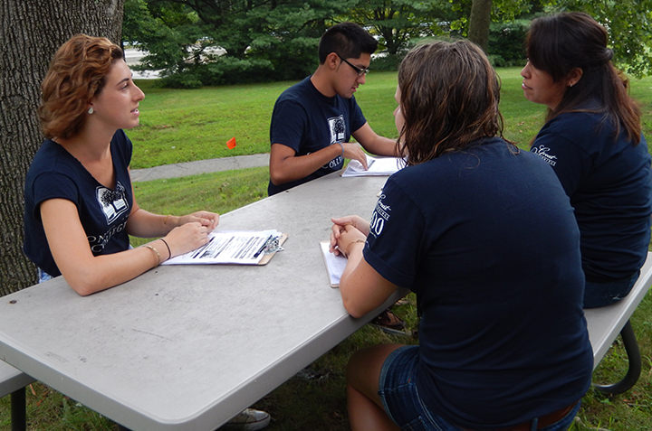 Sociology students discuss a project outside. 