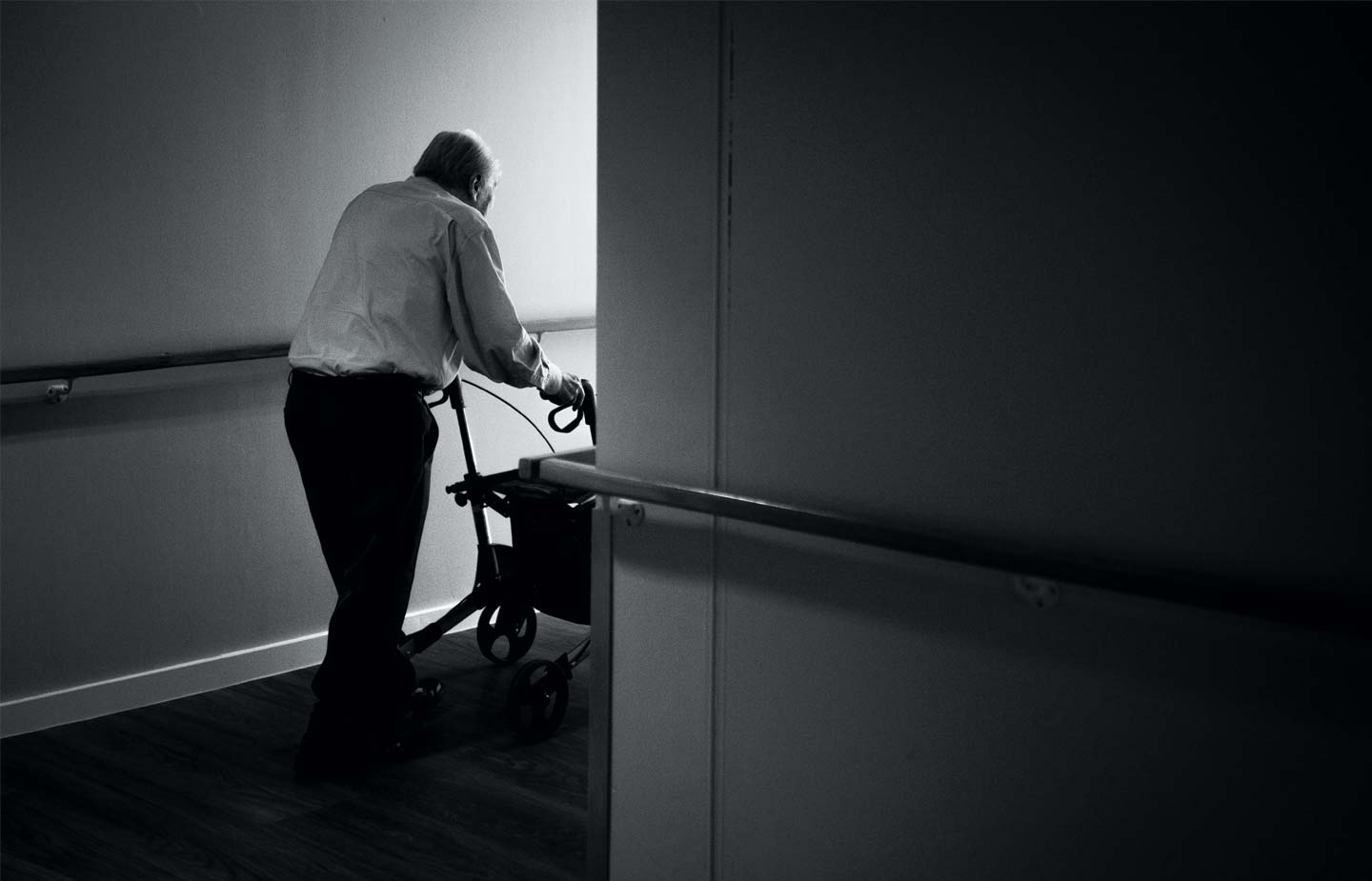 Elderly man pushing a wheelchair