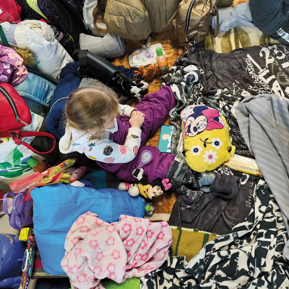 Image of young girl sitting among her scattered belongings