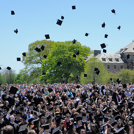 Graduating students throw up their caps in celebration. 