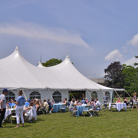 Alumni gather around the tent at Reunion. 