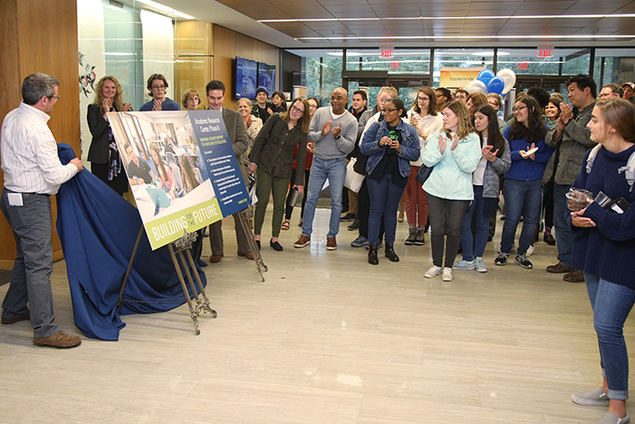 People cheer as the gift is announced. 