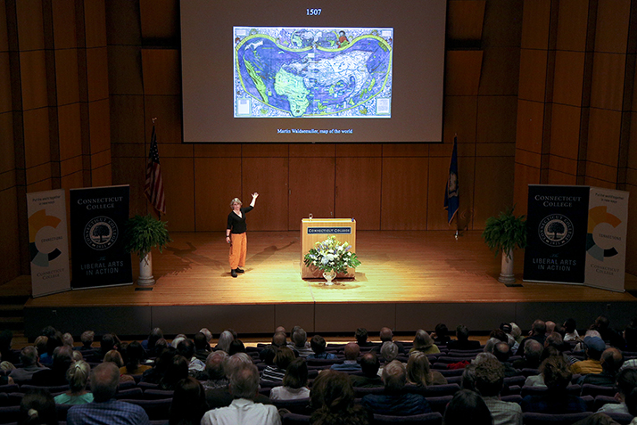 Lepore speaks on stage to a packed audience. 