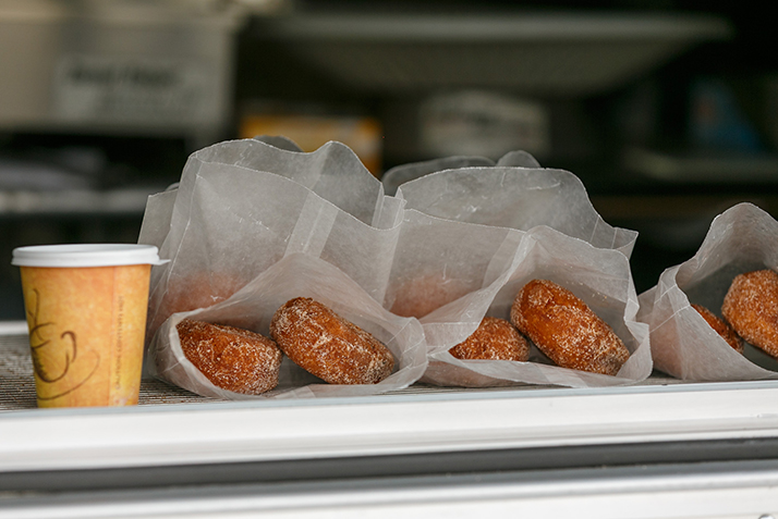 A close up of the donuts and apple cider.