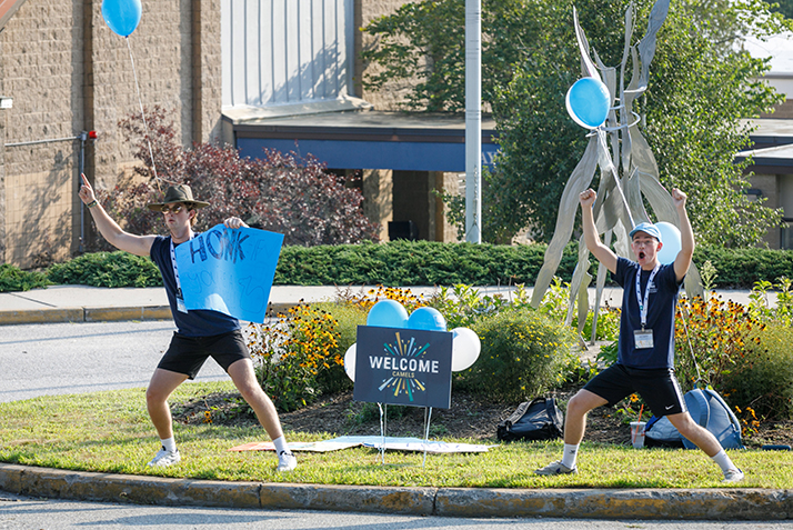 Students cheer as new students arrive.