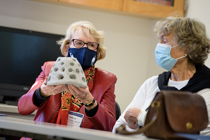 An alumna holds a small reef ball.