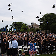 Members of the class of 2022 toss their caps.