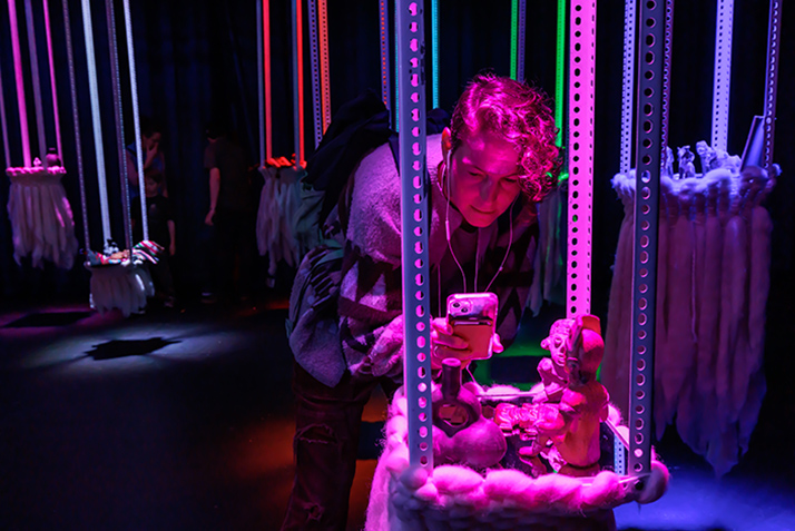 An Ammerman Center Symposium participant interacts with Anonymous Ensemble's Symposium display.