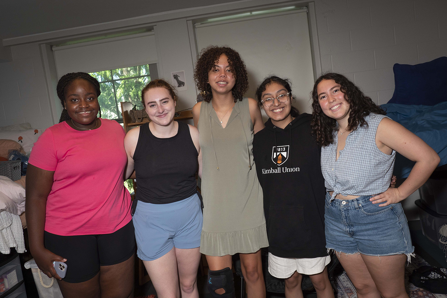 New students pose for a photo in a residence hall