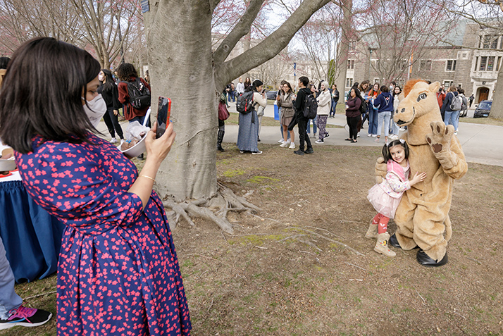 A parent takes a photo of a child with the Camel Mascot.