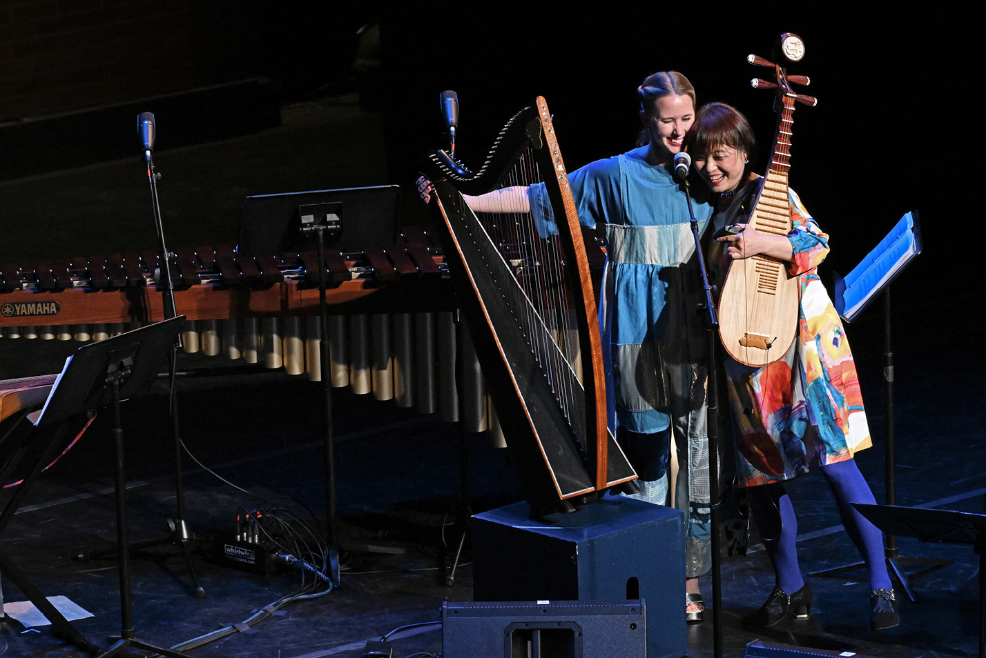 Two performers hugging on stage following a performance