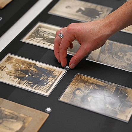 Hazel Johnstone ’26 places a number marker by a photograph in the display case.