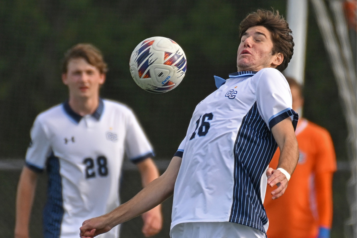 Men's soccer player fields a ball