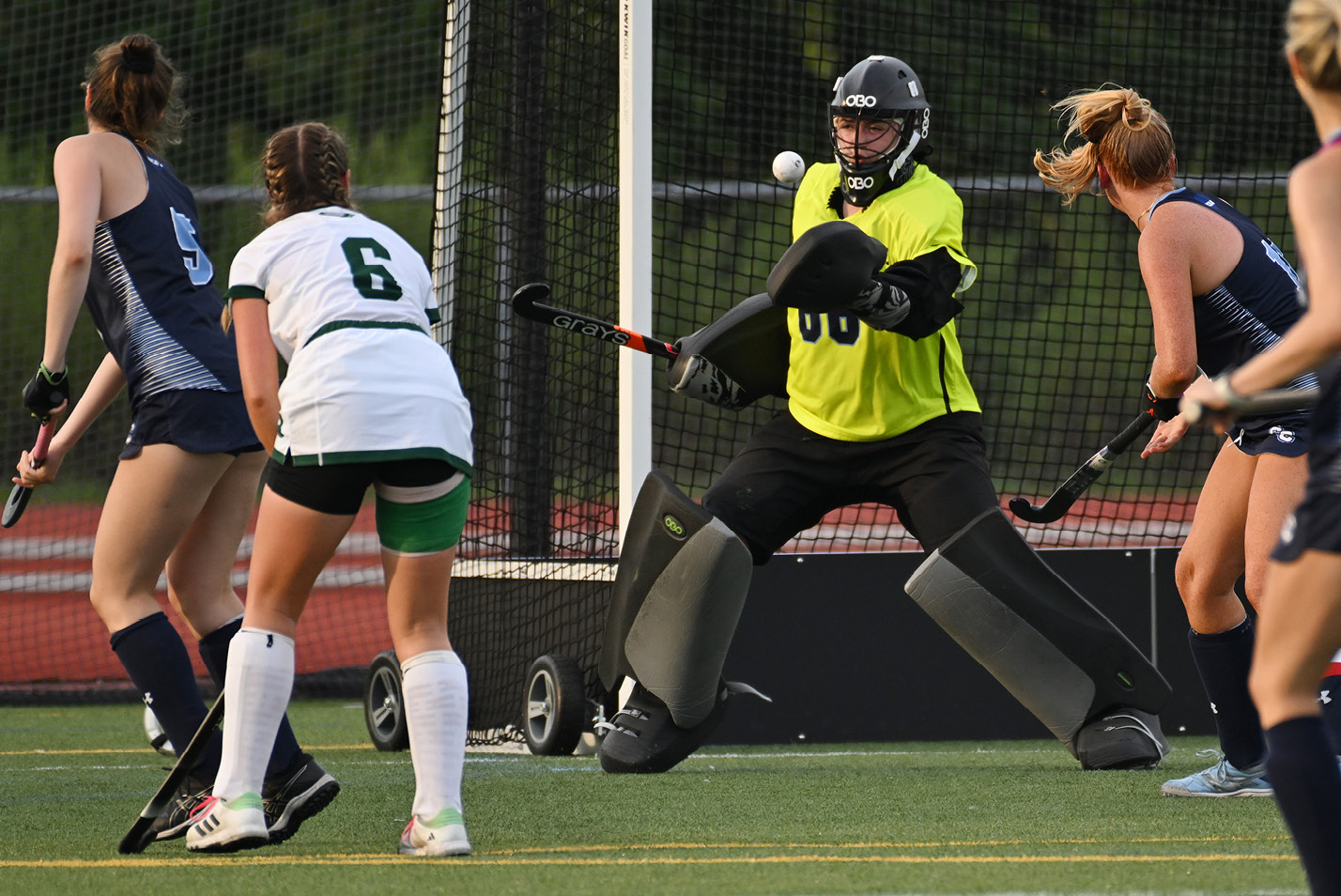 Women's field hockey goalie makes a save