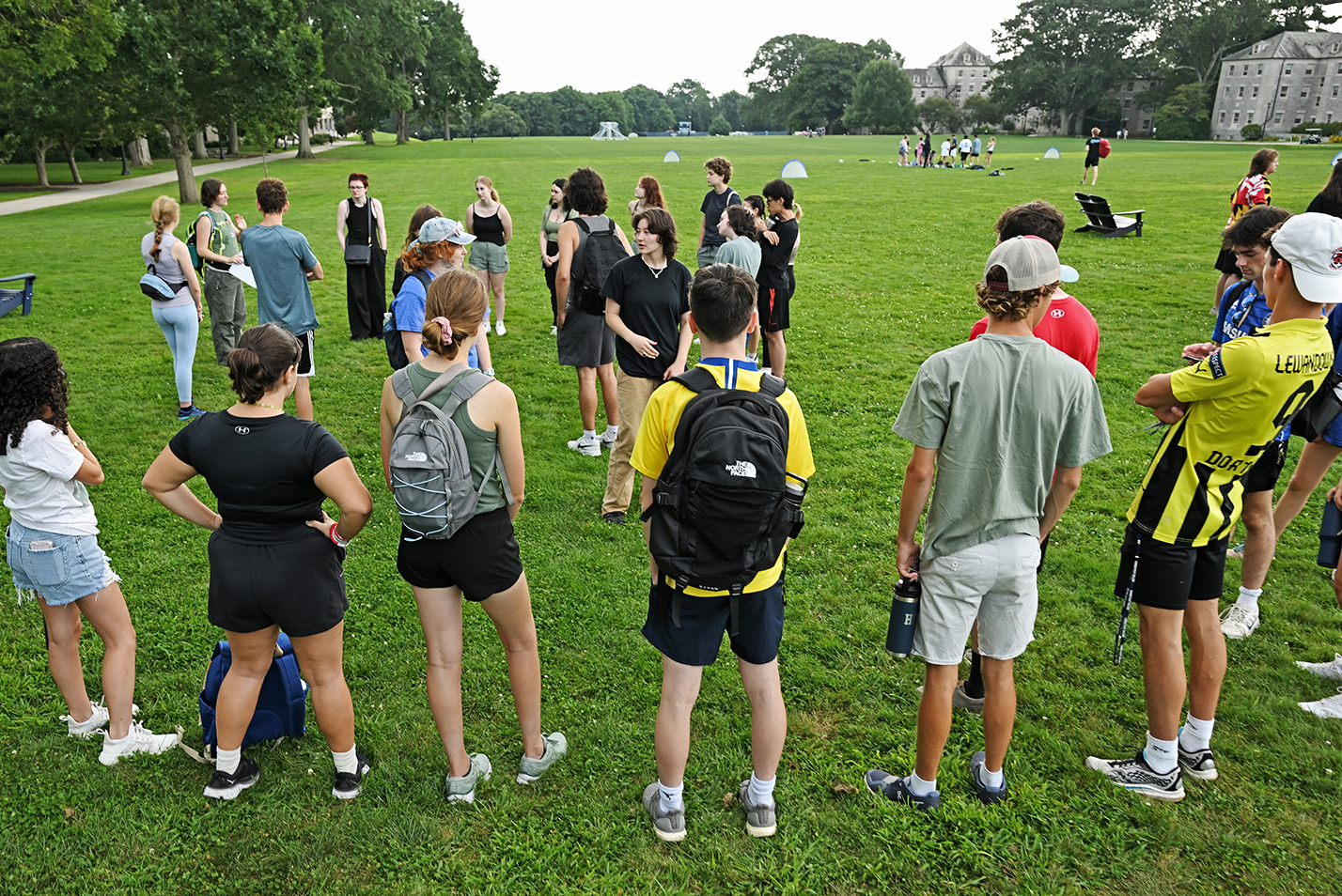 A group of college students gather on a green.