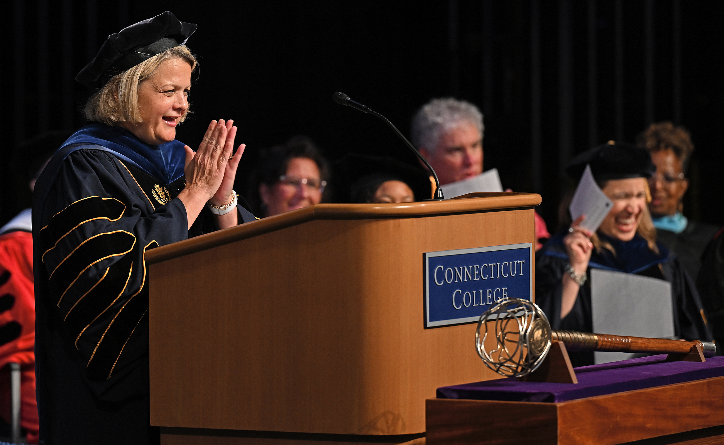 A college president speaks from a podium