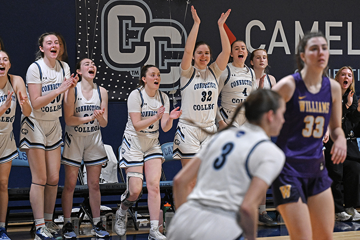 Women's basketball players celebrate from the bench