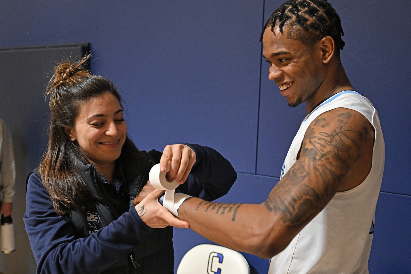 Trainer Sarah Acerbo tends to Connecticut College men's basketball guard Jarron Flynn '24 v. Wesleyan