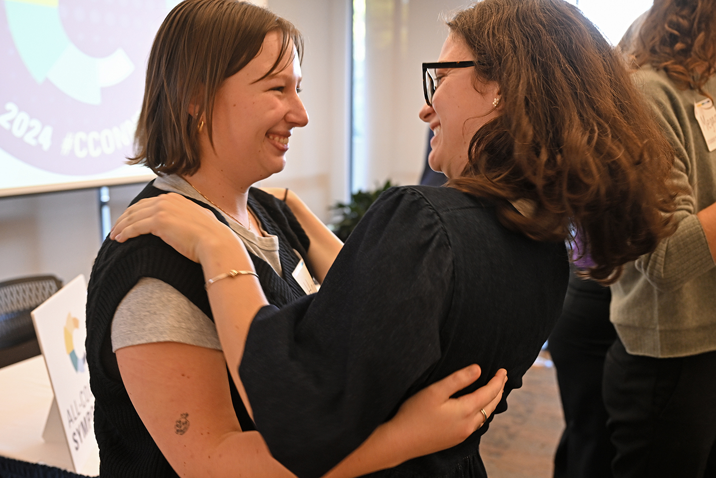 two students embrace after a successful presentation.