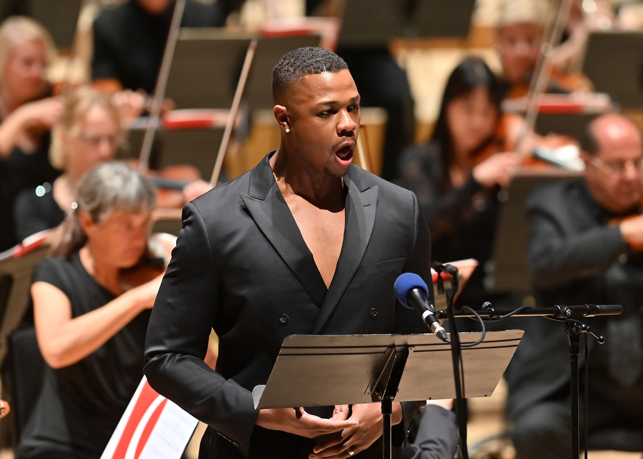 Davone Tines singing in front of an orchestra